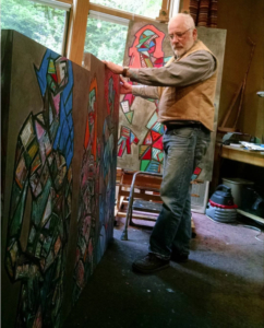 David Slader, artist, in studio with paintings